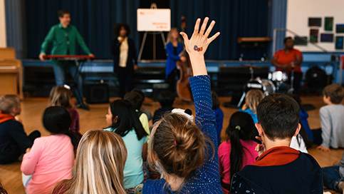 A girl raising her hand during an AIM program