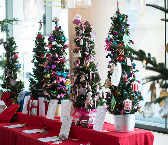 Mini-Trees for auction, decorated with colored ornaments.