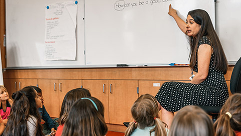 Children listen to a teacher in the classroom.