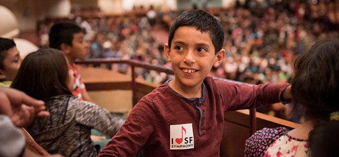 A student wearing an SF Symphony sticker sits in Davies Symphony Hall